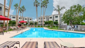 El Encanto Banner image of the pool area. Palm trees and lush landscape in the background.